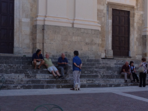 Men chatting on the stair to a church in Calvi dell'Umbria, Italy