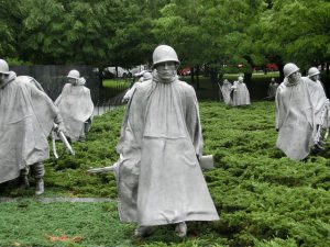 White ghostly figures walking over meadow