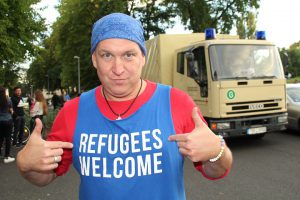 A man with "refugees welcome" written on his shirt