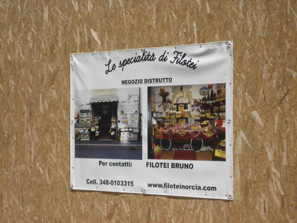 Photos of the destroyed shop behind the "curtain" and indication of where to contact the owner