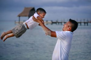 a men swinging a boy in the air