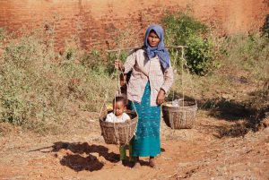 Woman carrying water and child